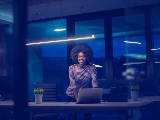 Jovem empresária afro-americana freelancer trabalhando usando um laptop no espaço de coworking