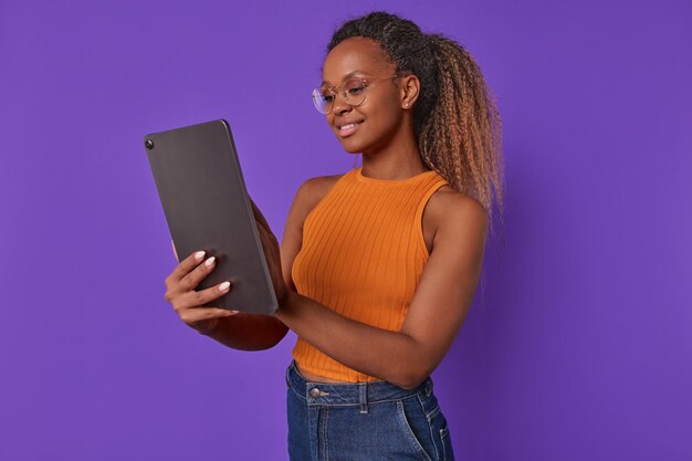 Jovem empresária afro-americana positiva com tablet eletrônico