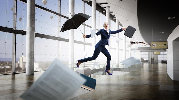 Jovem empresária andando com guarda-chuva. Mídia mista