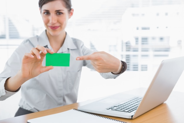 Jovem empresária apontando para cartão verde