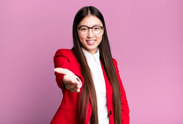 Jovem empresária asiática bonita vestindo blazer vermelho e óculos