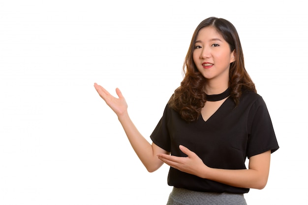 Jovem empresária asiática feliz mostrando algo isolado contra o branco