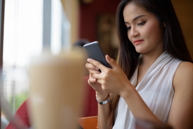 Jovem empresária asiática linda relaxante na cafeteria