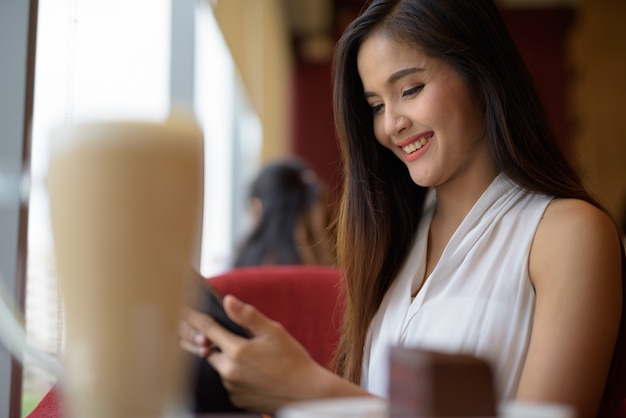 Jovem empresária asiática linda relaxante na cafeteria