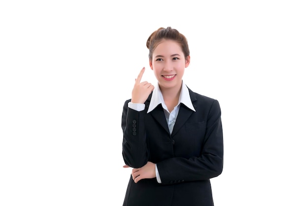 Jovem empresária asiática sorridente de terno preto e camisa branca apontando o dedo isolado no fundo branco