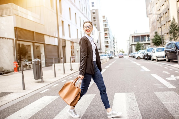 Jovem empresária atravessando a rua no moderno distrito comercial da cidade de lyon