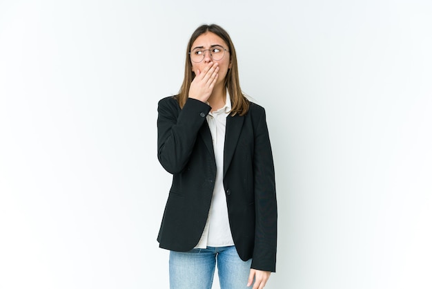 Jovem empresária caucasiana bocejando mostrando um gesto cansado, cobrindo a boca com a mão.