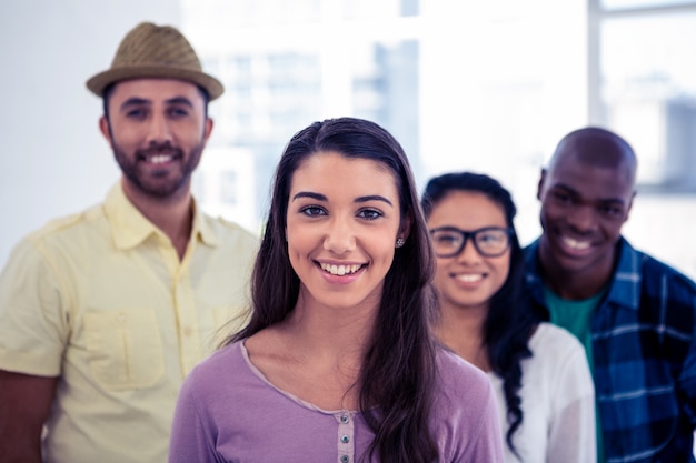 Jovem empresária de pé com equipe no escritório criativo