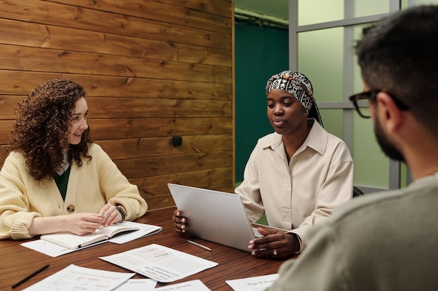 Jovem empresária e empresário ouvindo colega americano africano