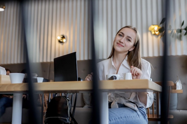 Jovem empresária em uma pausa para o café usando computador tablet