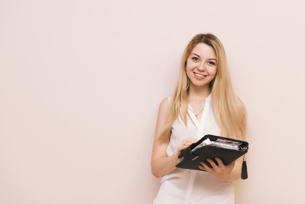 Foto jovem empresária loira segurando um caderno