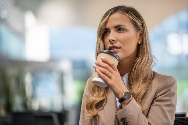 Jovem empresária loira tomando café