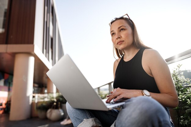 Jovem empresária loira usando laptop trabalhando no terraço em Istambul