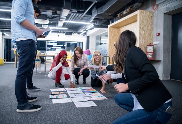 jovem empresária muçulmana negra tendo reunião com sua equipe de negócios de inicialização multiétnica no interior do escritório moderno, apresentando novas ideias no chão