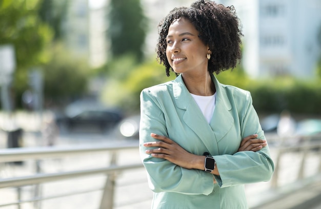 Jovem empresária negra posando ao ar livre olhando para o espaço de cópia