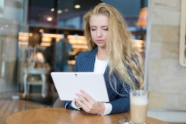 Jovem empresária no intervalo do café. usando computador tablet.