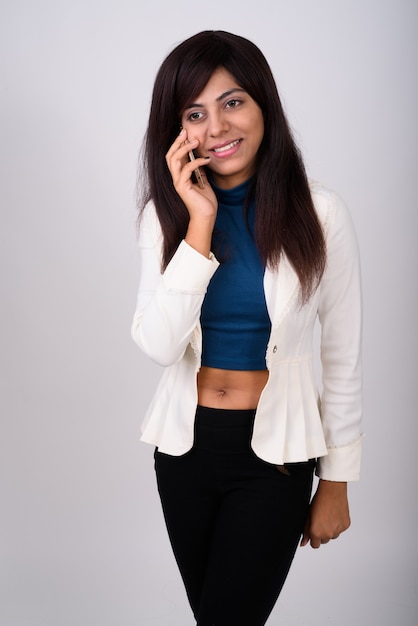 Foto jovem empresária pensativa e feliz sorrindo e em pé enquanto fala no celular