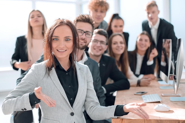 Jovem empresária sentada na frente de sua equipe de negócios