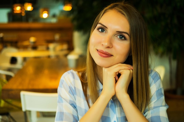 Foto jovem empresária sentada na mesa e trabalhando sorrindo e olhando para a câmera pessoas de estilo de vida e conceito de negócios