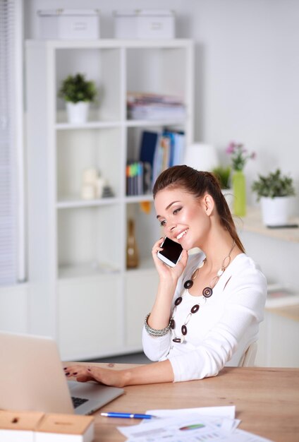 Jovem empresária sentado e falando no telefone