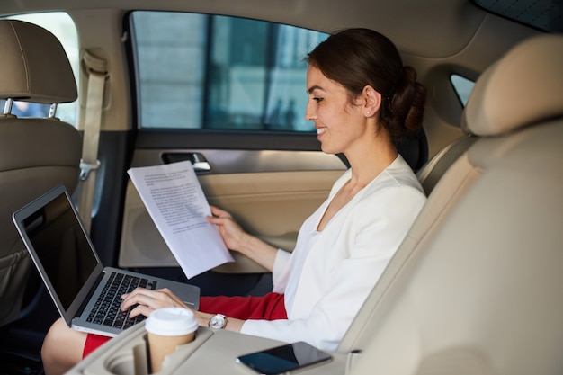 Jovem empresária trabalhando no carro