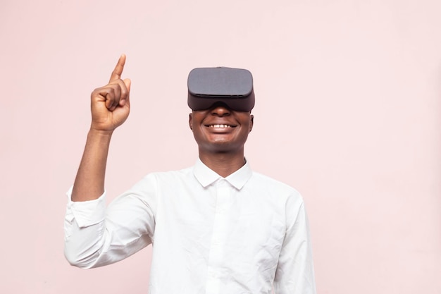 Jovem empresário africano apontando um dedo para cima enquanto usava uma realidade virtual moderna