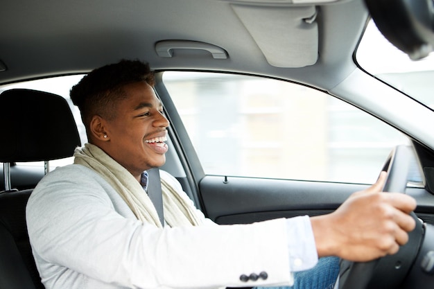 Jovem empresário afro-americano a conduzir um carro.