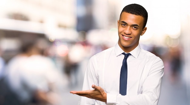 Jovem empresário afro-americano, apresentando uma ideia enquanto olha sorrindo para a cidade