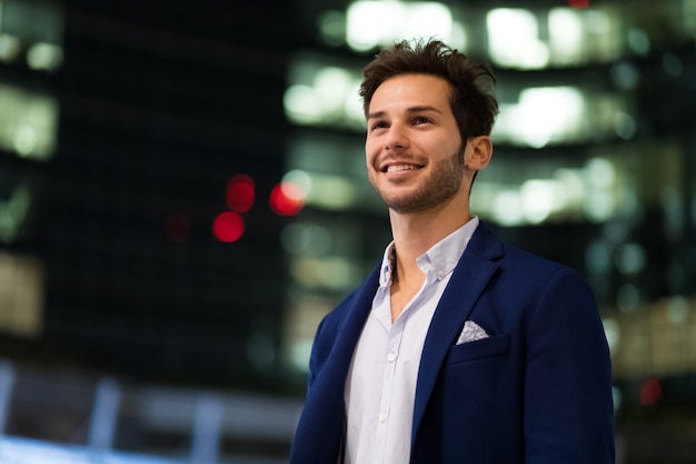 Foto jovem empresário ao ar livre em um ambiente moderno da cidade à noite