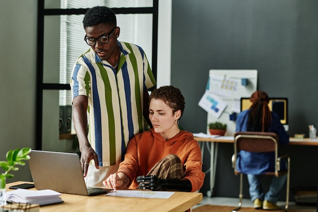 Jovem empresário apontando para a tela do laptop durante a apresentação