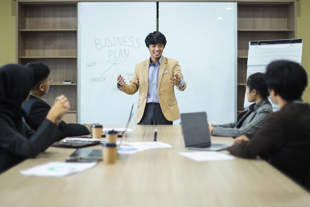 Jovem empresário apresenta plano de negócios ao trabalhador durante reunião no escritório.