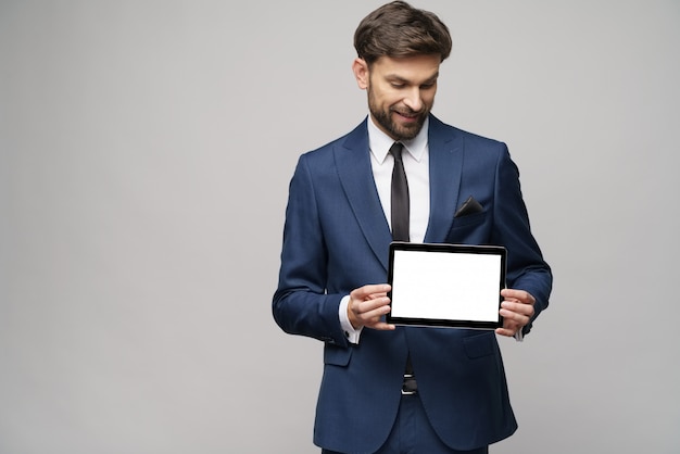 Jovem empresário apresentando digital tablet pc pad com tela em branco