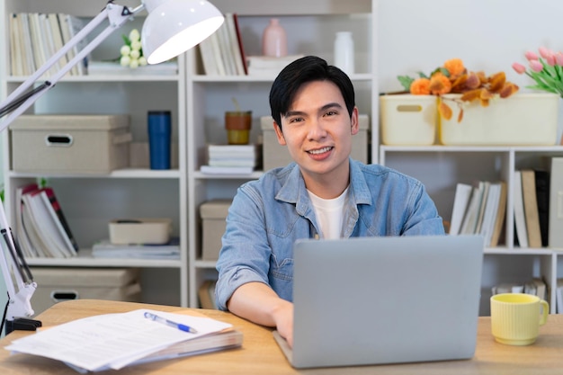 Jovem empresário asiático a trabalhar em casa.