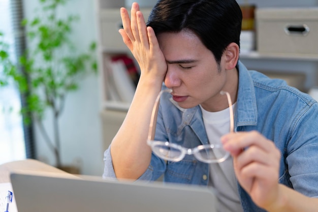 Jovem empresário asiático a trabalhar em casa.