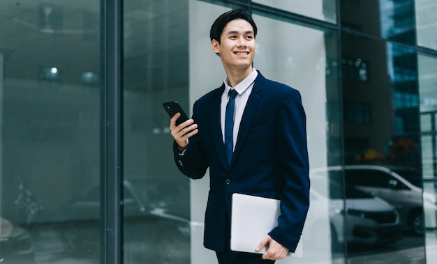 Jovem empresário asiático com construção de vidro