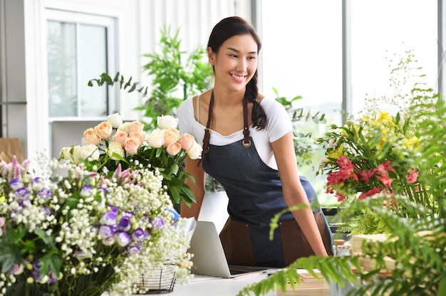 Jovem empresário asiático / dono de loja / florista de um pequeno negócio de loja de flores