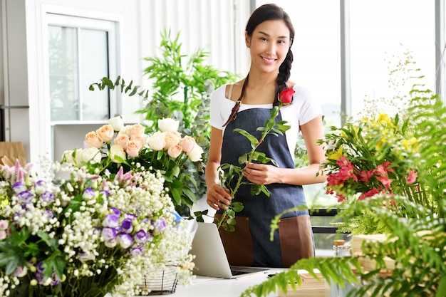 Jovem empresário asiático / dono de loja / florista de um pequeno negócio de loja de flores