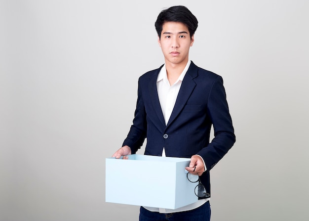 Jovem empresário asiático segurando uma caixa