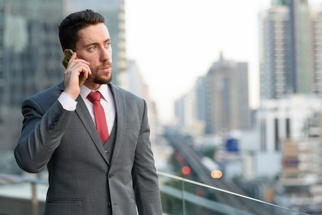 Jovem empresário bonitão falando no celular no