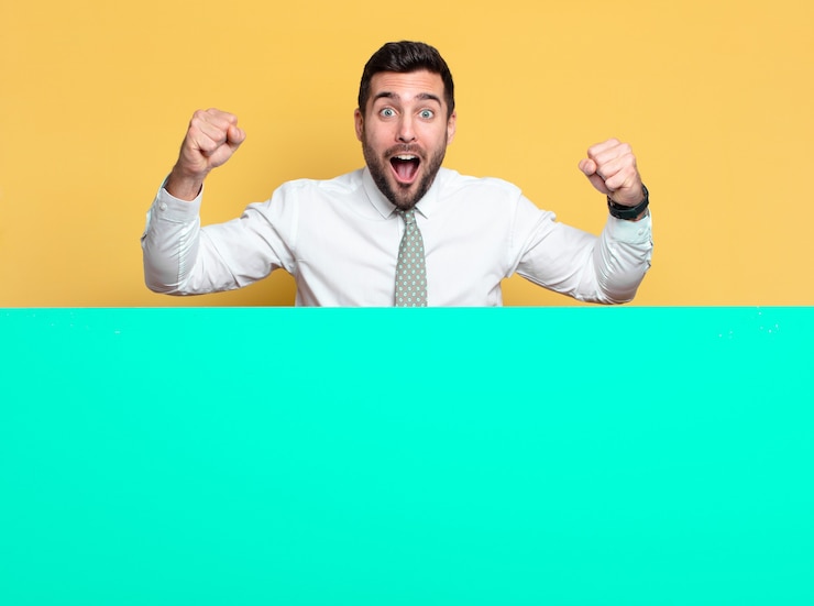 Foto jovem empresário bonito celebrando ou gesto triunfante