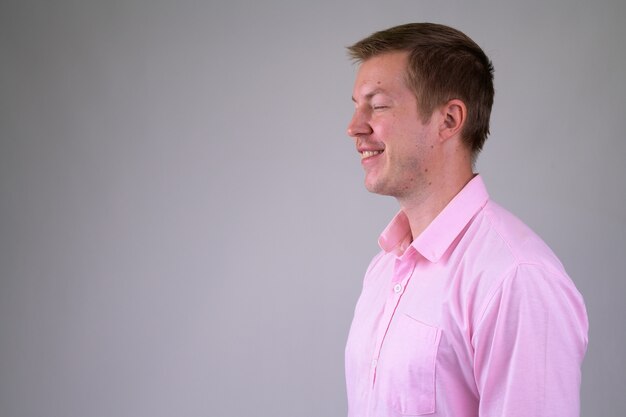 Jovem empresário bonito com camisa rosa