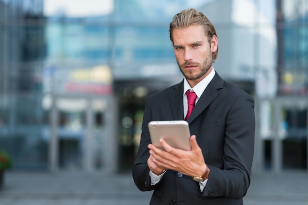 Jovem empresário bonito usando seu tablet