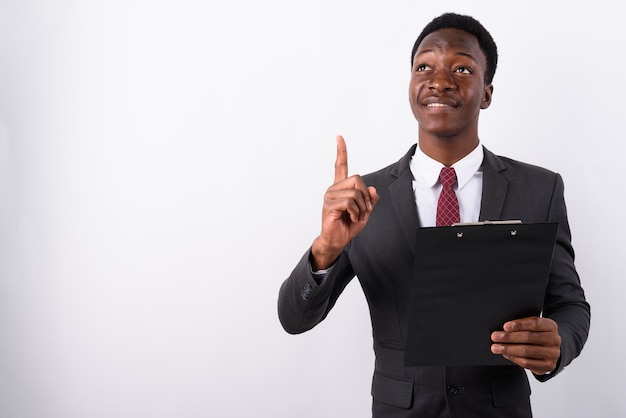 Jovem empresário bonito vestindo terno contra branco