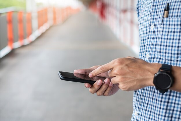 Foto jovem empresário casual segurando e usando smartphone