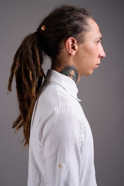 Foto jovem empresário com dreadlocks contra um fundo cinza