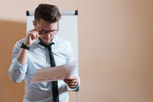 Foto jovem empresário confuso estudando documentos