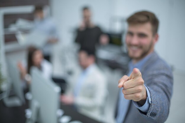 Foto jovem empresário de pé no escritório e apontando o dedo para você o conceito de escolha