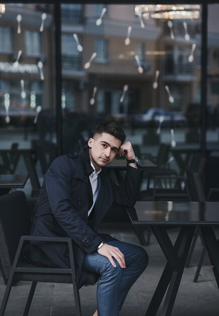 Jovem empresário de sucesso está sentado a uma mesa em um café perto do escritório