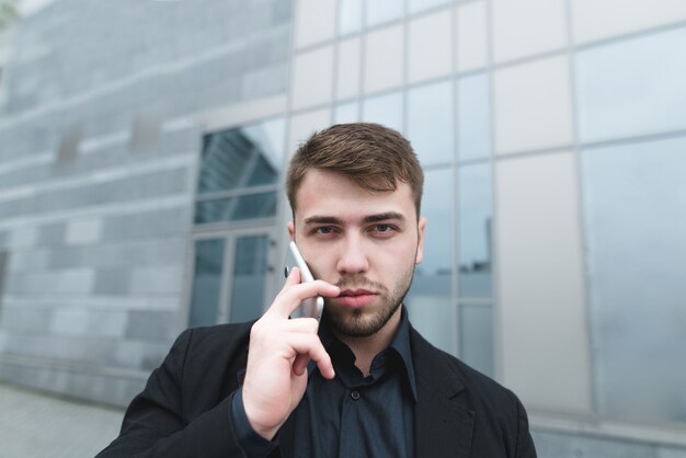 Jovem empresário de terno falando ao telefone