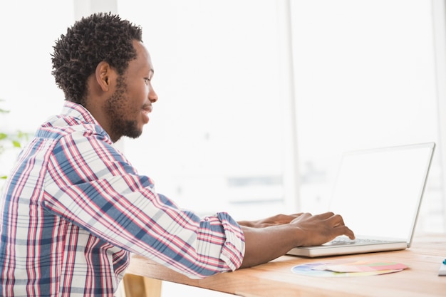 Jovem empresário digitando no laptop